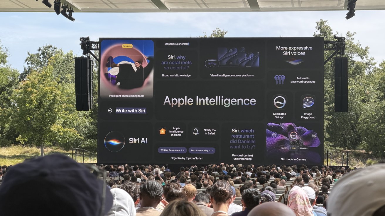 Large outdoor Apple event audience facing a giant screen presenting Apple Intelligence features, Siri AI enhancements, and colorful graphics, with trees and open sky visible in the background